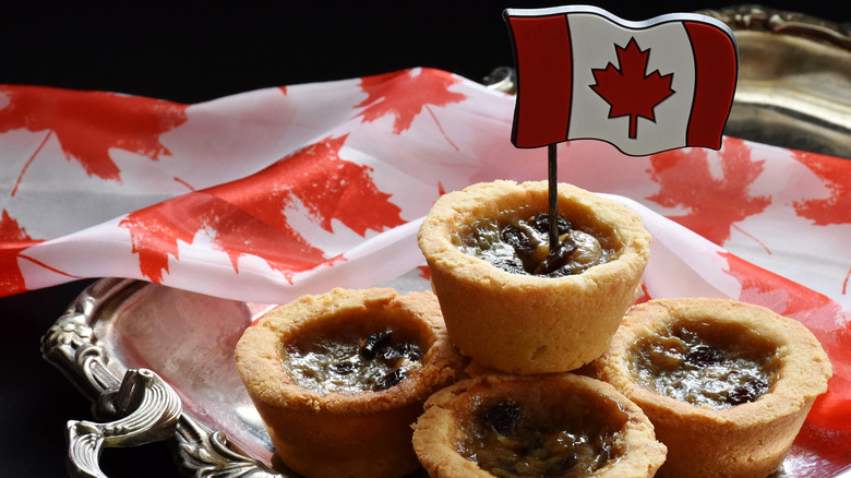 Delicious Butter Tarts photographed on a silver tray with Canadian flag and fabric.