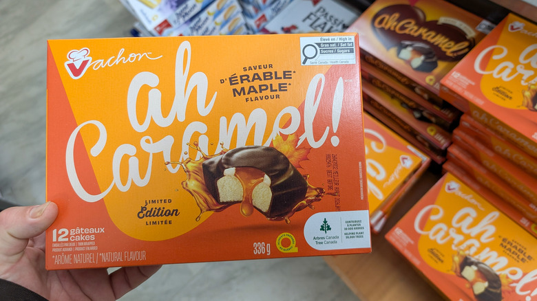 Consumer holds Vachon Ah Caramel! Maple Flavour Limited Edition snack cakes in a retail store