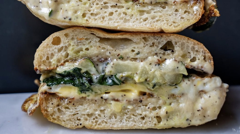 Breakfast sandwich sliced in half with egg and creamy sauce for Seattle brunch