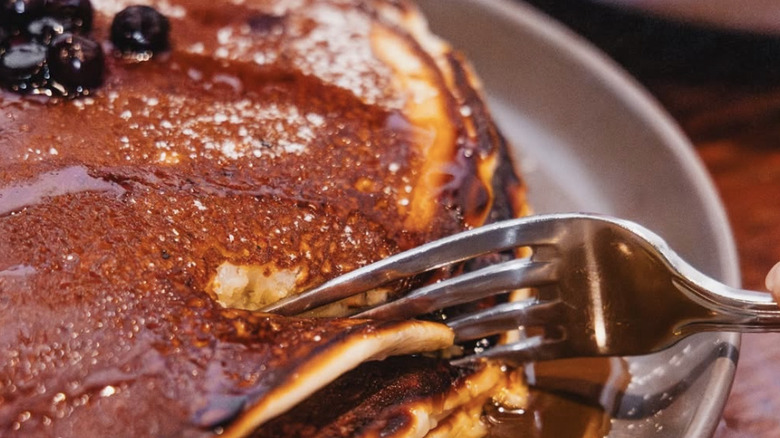 Huckleberry pancake stack cut by a fork
