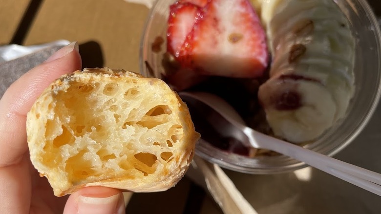 Hand holding pao de quiejo at Seattle brunch spot