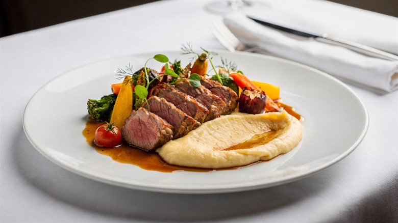 Sliced steak and potatoes on a plate