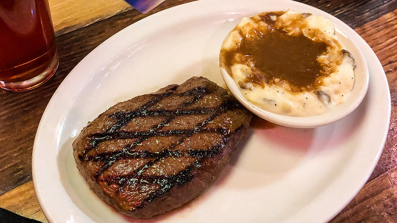 A steak and mashed potatoes with gravy from Texas Roadhouse on a plate
