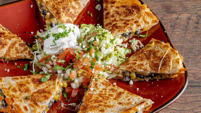 Plate of quesadillas with guacamole, salsa, and sour cream at La Viva Tex Mex