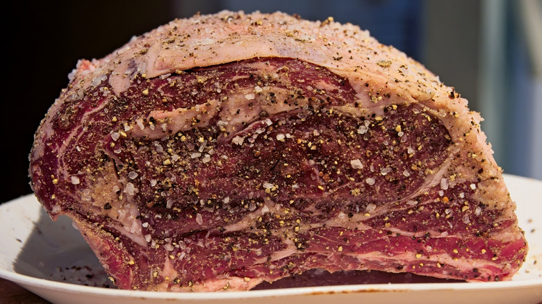 Close up of raw seasoned prime rib roast