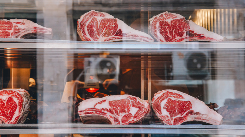 Prime rib dry-aging behind glass