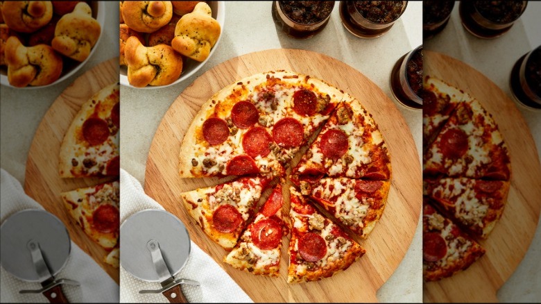 Great Value Rising Crust Three Meat Pizza on a serving board