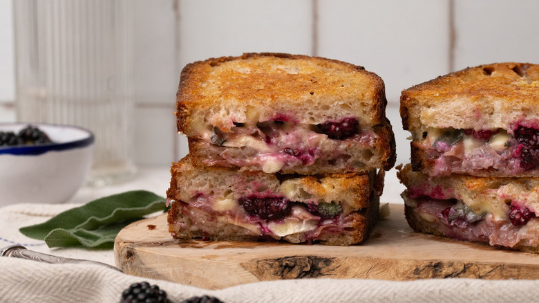 Blackberry grilled cheese sandwiches stacked on wooden board