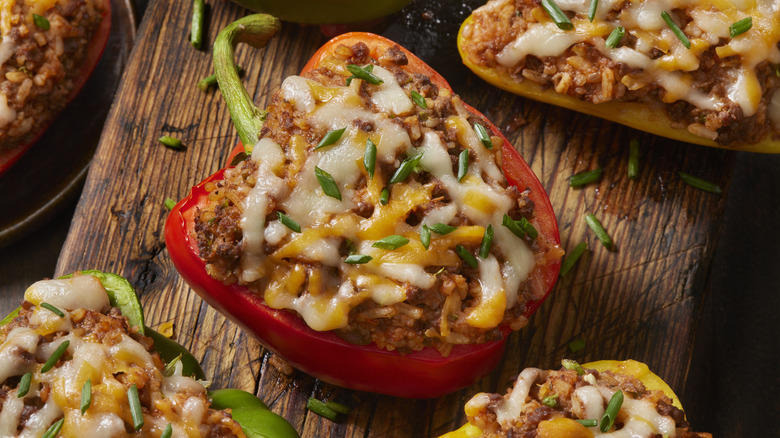 Cheesy beef stuffed peppers on wooden board