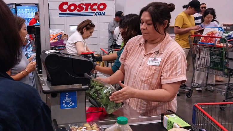 Costco female employee checking out groceries