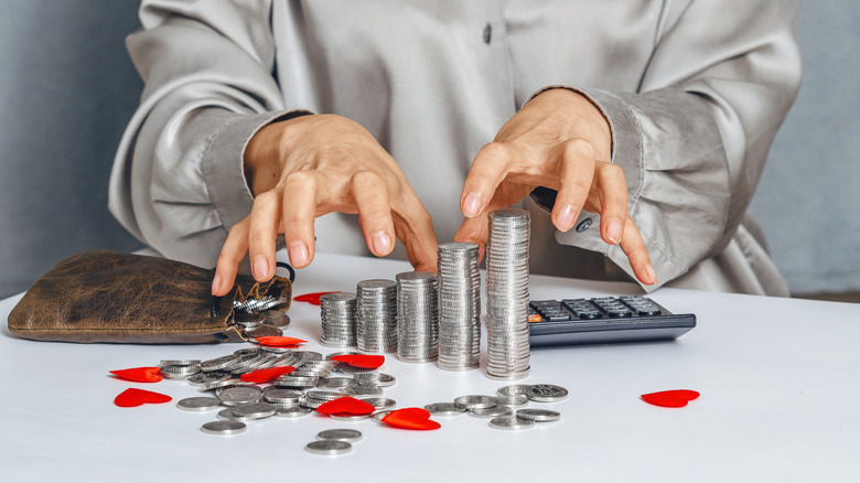 Woman's hands reaching for a bunch of coins