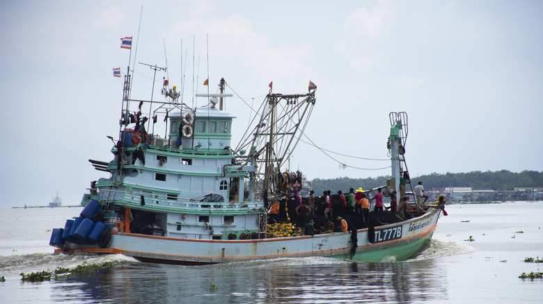 Thai commercial fishing boat in the water with workers
