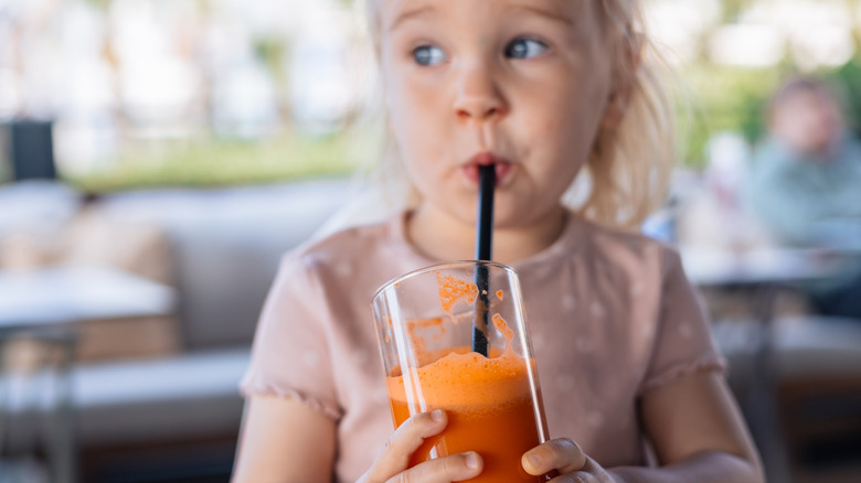 toddler drinking juice through straw