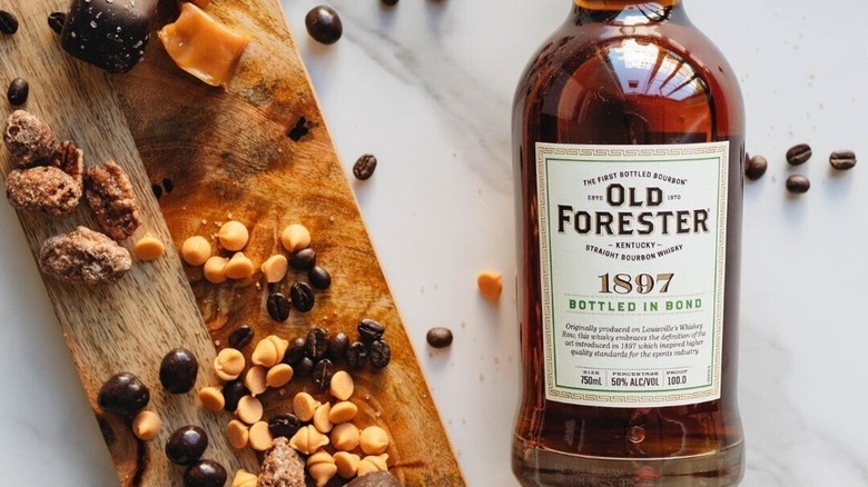 Old Forester 1897 Bottled-in-Bond on a marbled counter with a cutting board covered in chocolate and caramel chips