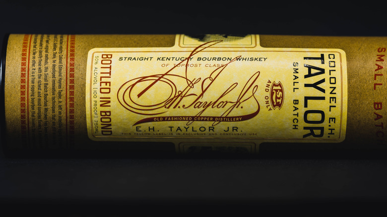 A bottle of E.H. Taylor, Jr. Small Batch laid on its side on a plain black background