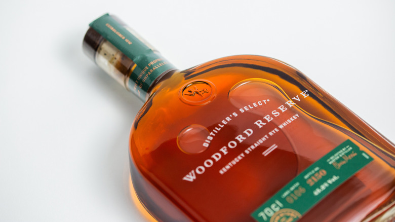 A bottled of Woodford Reserve Distiller's Select laid on its side on a plain white background