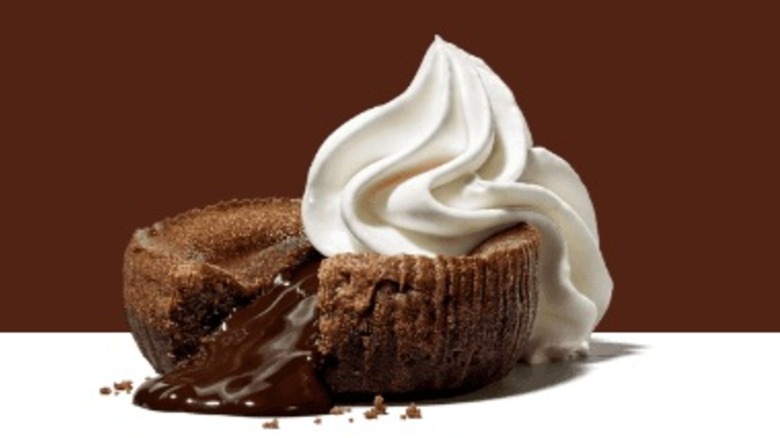 A brownie with gooey chocolate topped with vanilla ice cream