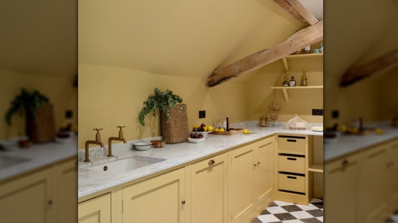 A kitchen with no backsplash and butter-yellow walls