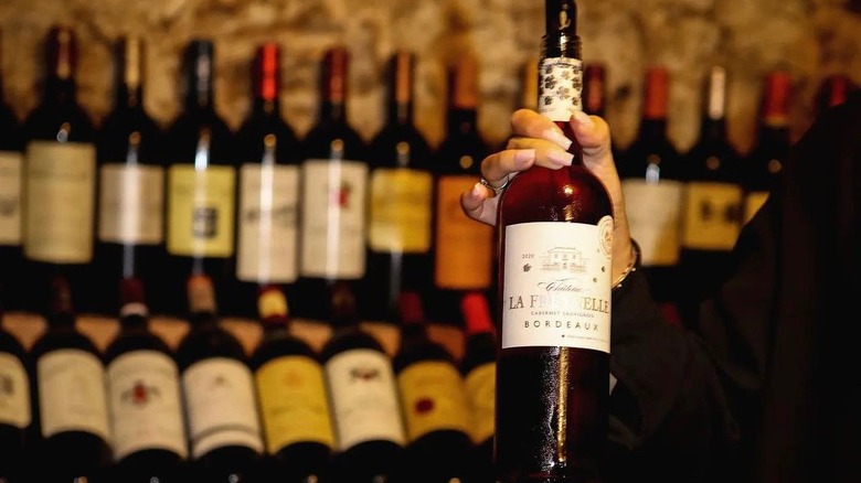 Bottle of Château La Freynelle Cabernet Sauvignon Bordeaux with bottles in the background