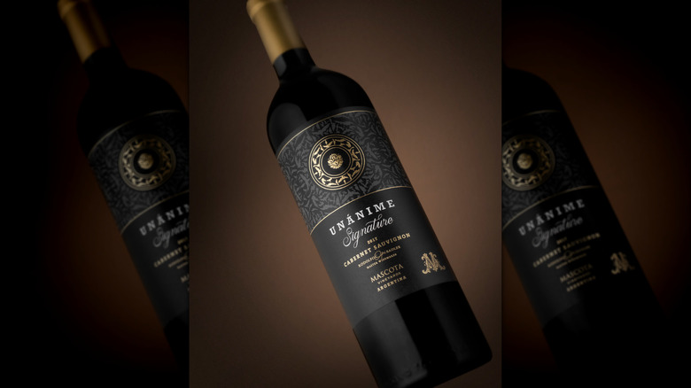 Bottle of red Unánime Signature Cabernet Sauvignon wine on its side