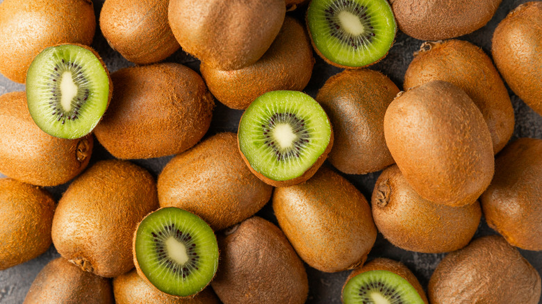 Overhead view of whole and halved kiwi fruit