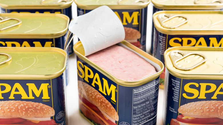 Opened can of Spam surrounded by other sealed cans