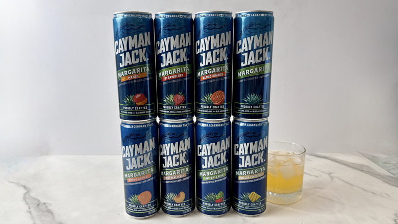 cans of Cayman Jack tequila cocktails and glass with cocktail