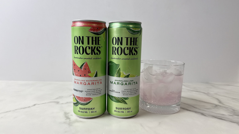 cans of On the Rocks tequila cocktails and glass with cocktail