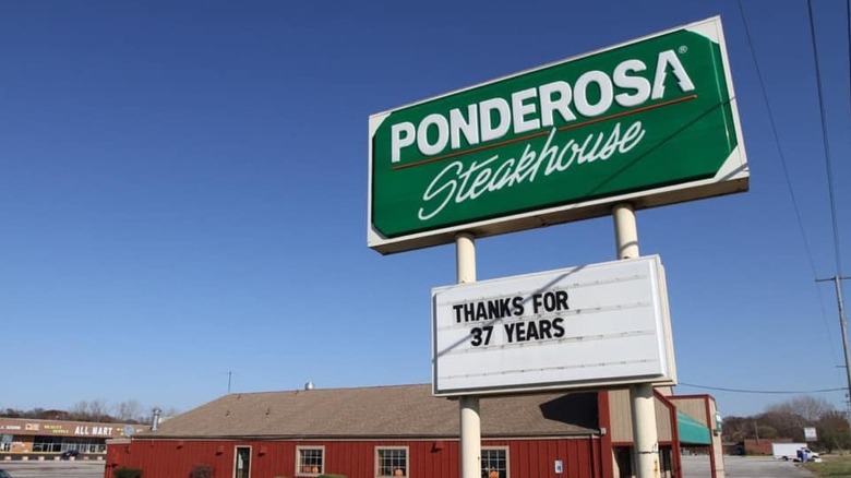 Ponderosa Steakhouse sign in front of empty parking lot and red restaurant