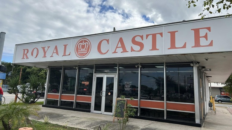Royal Castle restaurant in front of garden with cloudy sky in the background