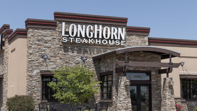 LongHorn Steakhouse sign on restaurant with tree in front