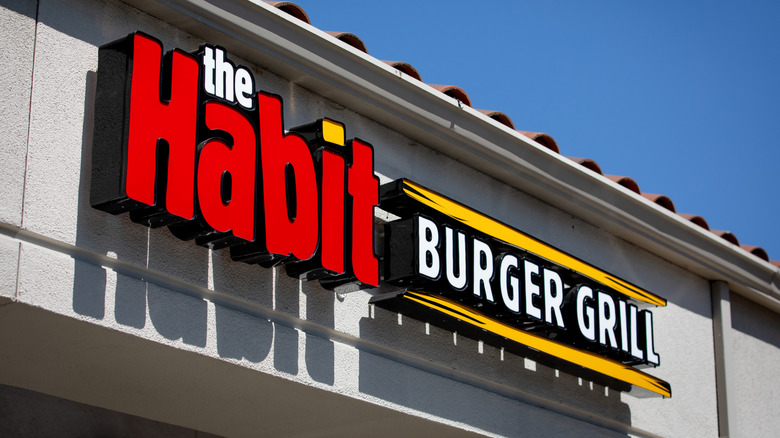 The Habit Burger and Grill restaurant sign on building against blue sky