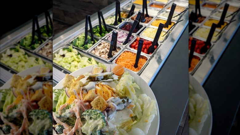 Plate of salad in front of Shoney's salad bar