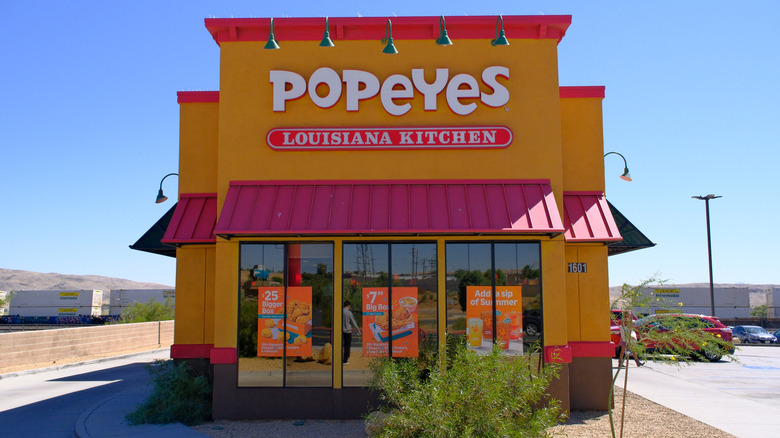Side view of a Popeyes restaurant, with the name above an awning and windows