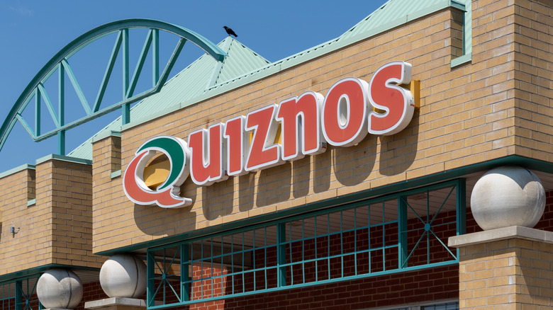The exterior of a Quiznos restaurant, focused on the name above the entrance