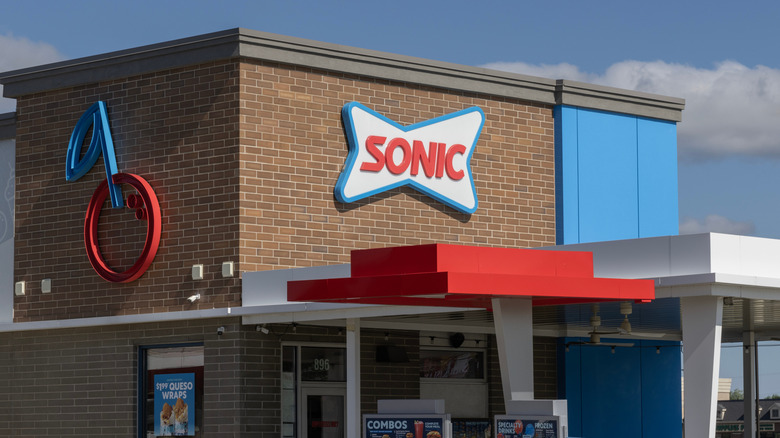 The exterior of a Sonic Drive-In focused on the sign, from the drive thru angle