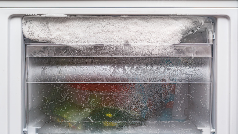 Opened freezer with frost on drawer