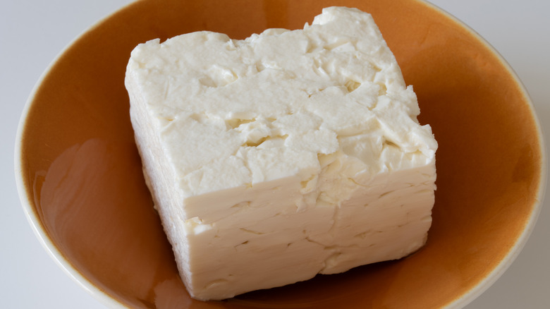 Block of feta cheese in bowl