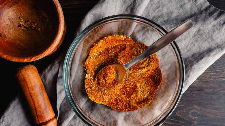 A bowl of dry rub with a spoon