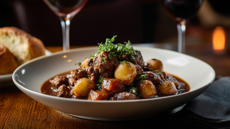 A bowl of beef stew with carrots and potatoes