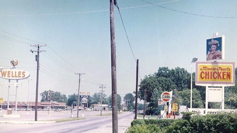 a sign for minnie pearl's fried chicken on the side of the road