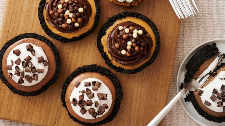 Top view of mini chocolate pies topped with chocolate pearls and shavings.