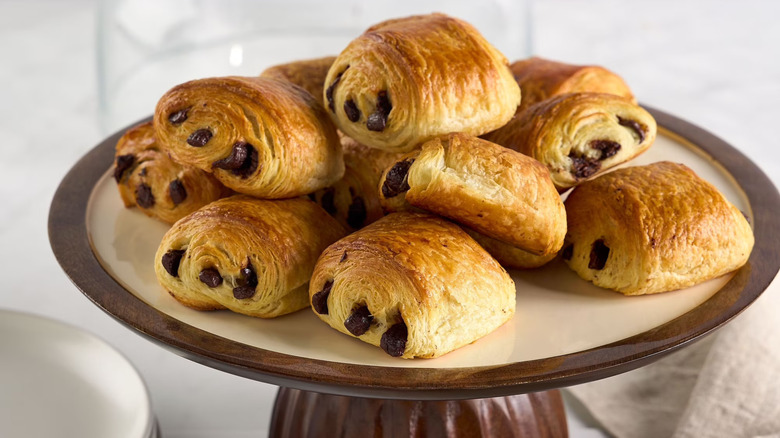 Pains au chocolat displayed on a cake stand.