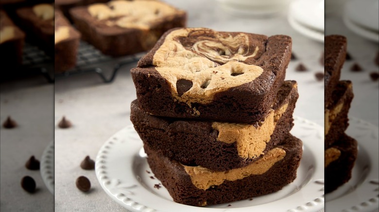Three cookie dough brownie squares stacked atop each other.