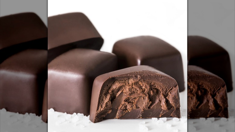 Dark Chocolate Truffle Bites from Utah Truffles with sea salt sprinkled around on a white background