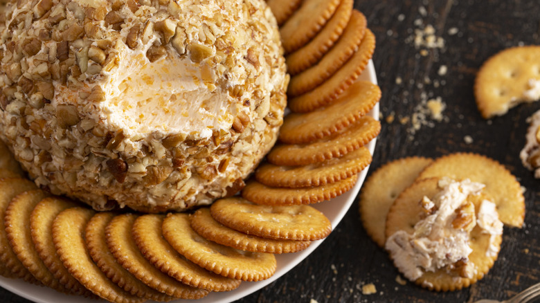 A cheese ball on a plate of butter crackers