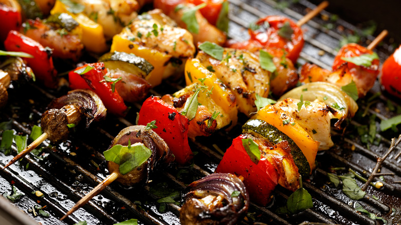 Several kabobs sitting on a grill