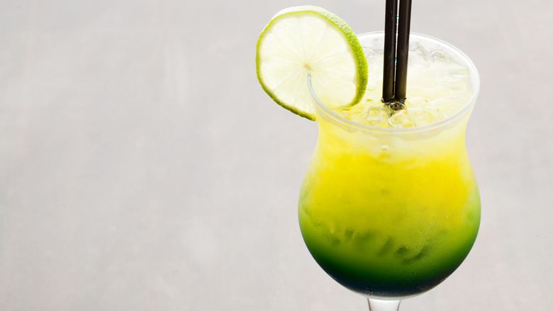 Green and yellow cocktail with lime wheel garnish