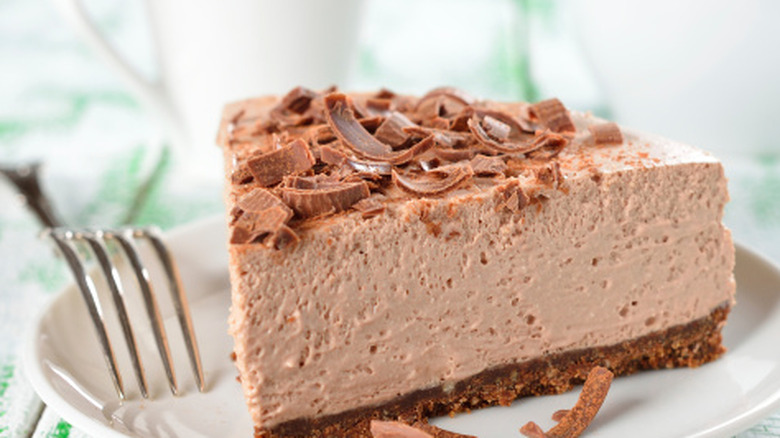 Slice of chocolate cheesecake on a plate with a fork