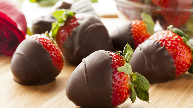 chocolate covered strawberries on a wooden board